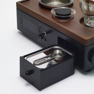 Drawer of Barisieur Coffee Maker and Alarm Clock with storage for coffee grounds and stainless steel measuring spoon