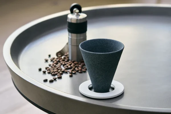 Cerapotta ceramic coffee filter with a ring holder, placed on a table with coffee beans and a manual grinder