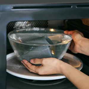 Cerapotta ceramic coffee filter being deep cleaned in the microwave with a water-filled glass bowl