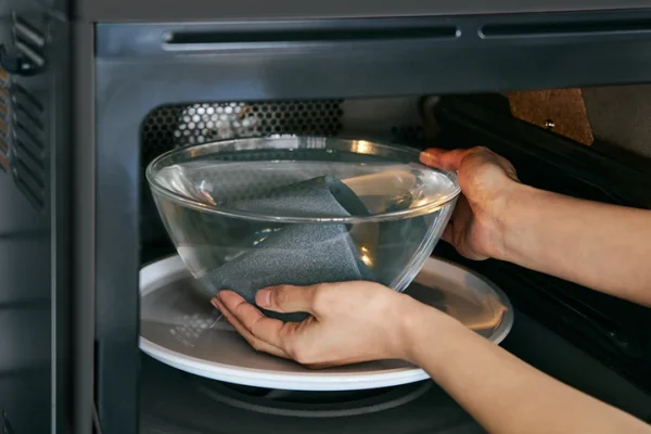 Cerapotta ceramic coffee filter being deep cleaned in the microwave with a water-filled glass bowl