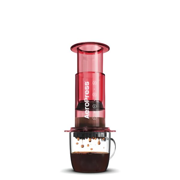 Red AeroPress coffee maker creating a rich coffee brew in a mug.
